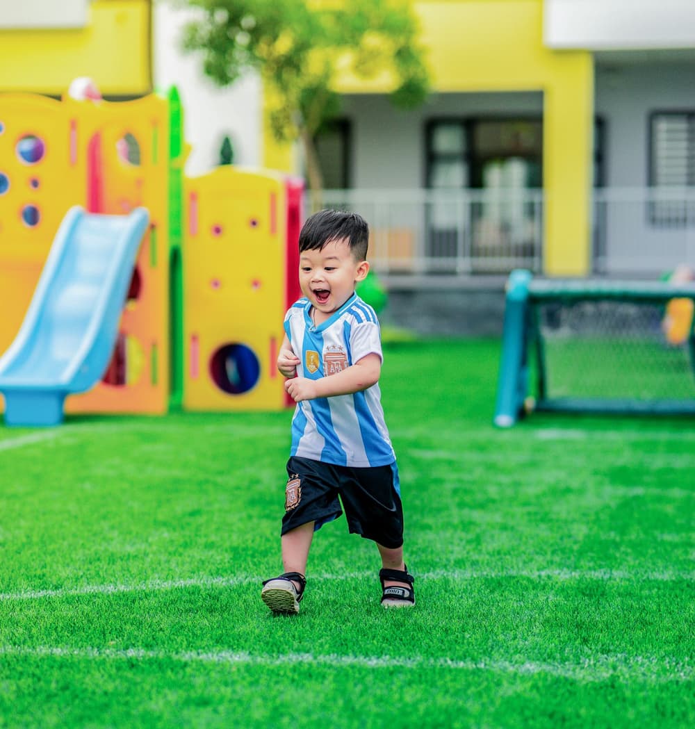 Bambino felice con la maglia da calcio dopo una corsa in campo